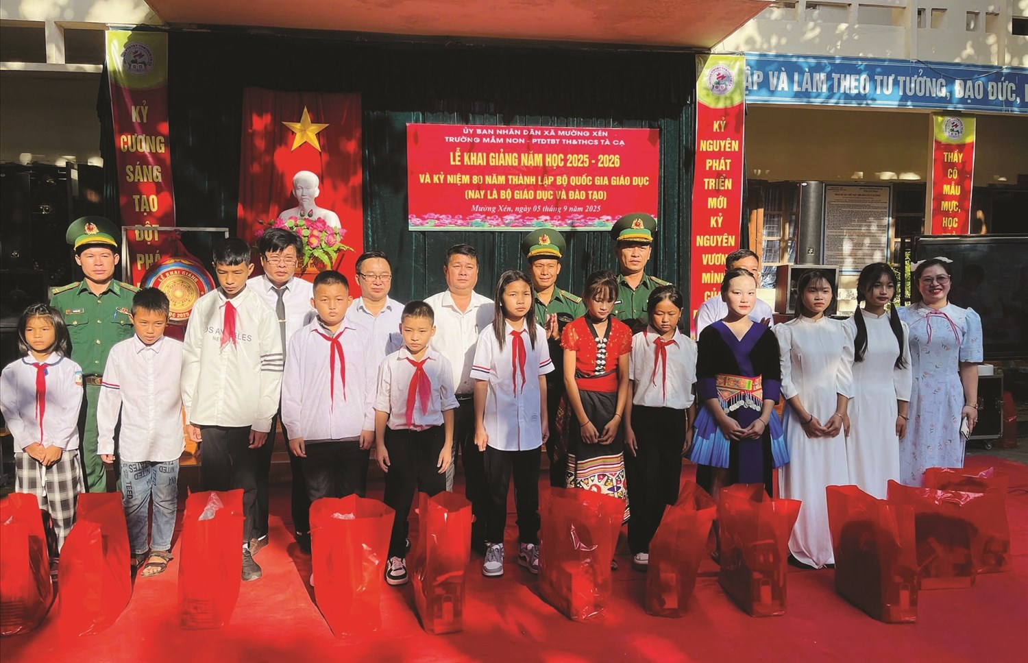 Chiến sĩ Đồn Biên phòng Nậm Cắn trao quà và đưa em Khun Thị Hà My (thứ 6 từ phải qua trái) đi khai giảng năm học mới