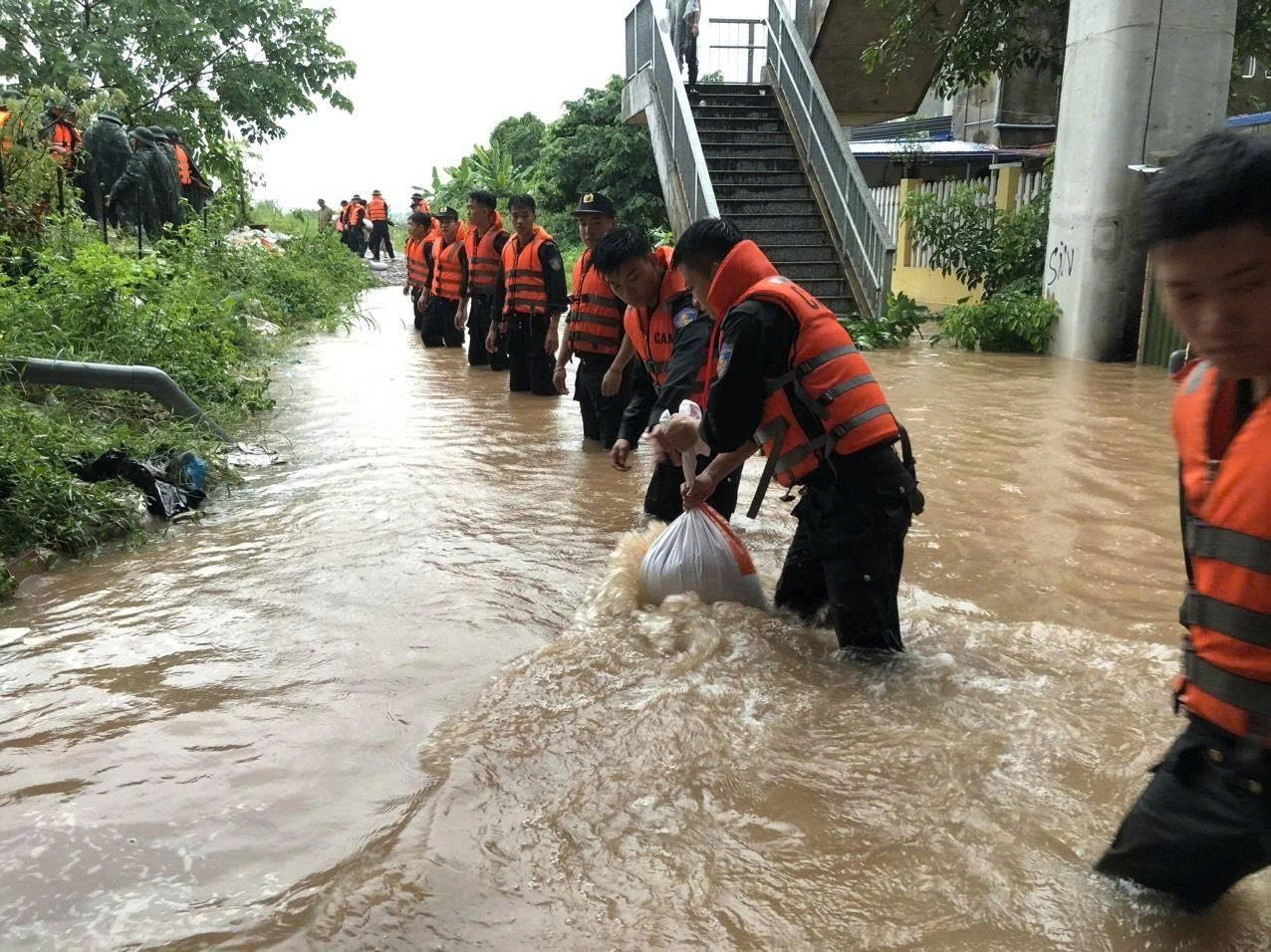 Các lực lượng đang chạy đua với thời gian để nâng bờ đê lên khoảng 50cm trước 14 giờ chiều nay.. (Ảnh: Nguyễn Liên)