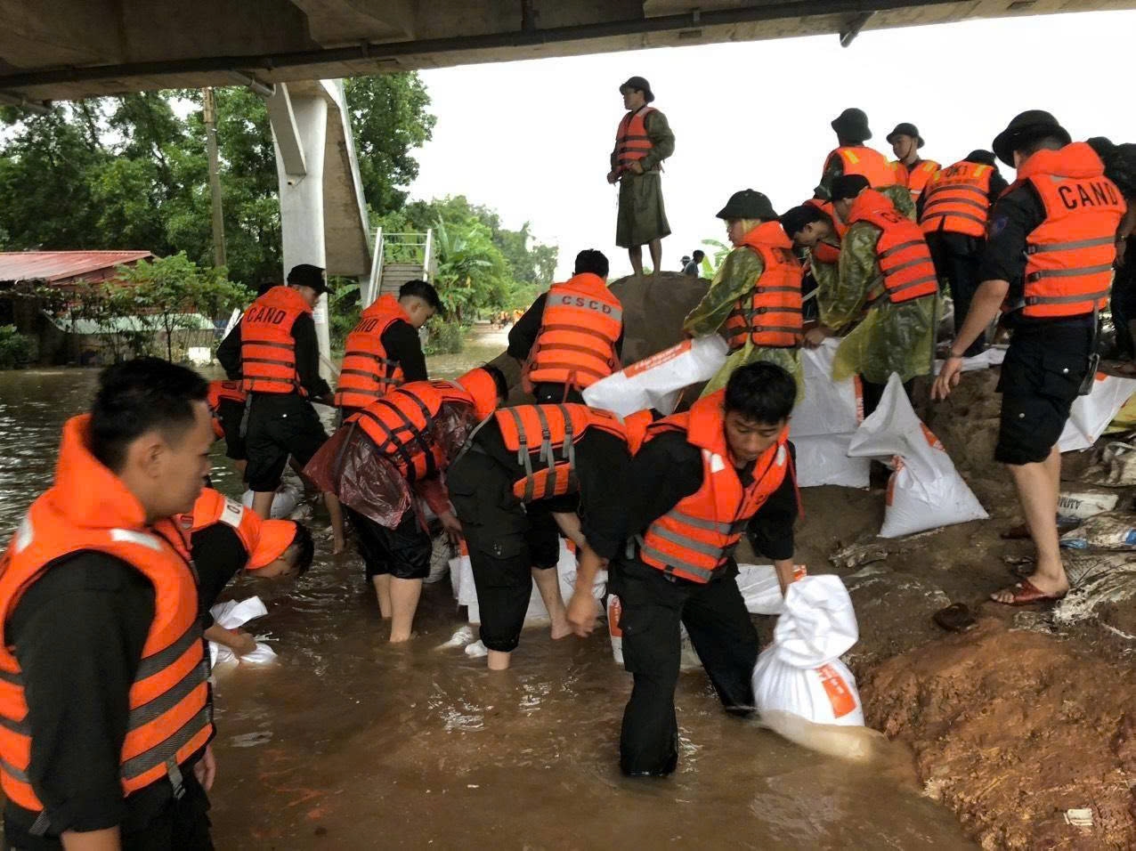 Các lực lượng đang chạy đua với thời gian để nâng bờ đê lên khoảng 50cm trước 14 giờ chiều nay.. (Ảnh: Nguyễn Liên)