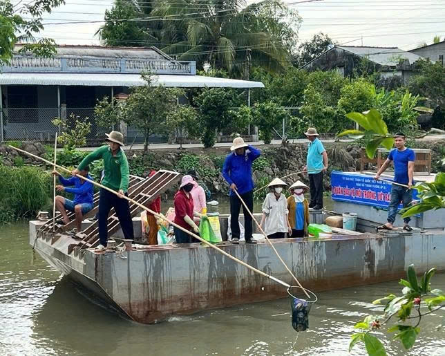 Đảng viên trẻ cùng giáo dân vớt rác.