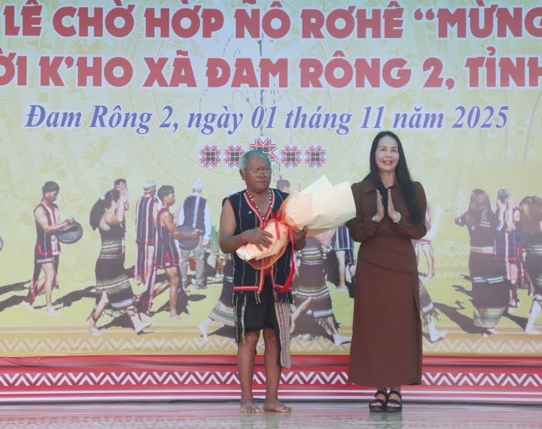 Bà Nguyễn Thị Bích Ngọc, Phó Giám đốc Sở Văn hóa, Thể thao và Du lịch tỉnh Lâm Đồng tặng hoa cho già làng Liêng Hót Ha K'Ràng