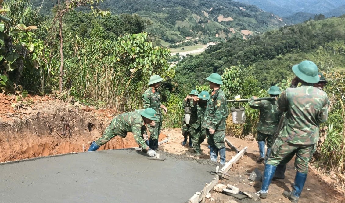 Lực lượng bộ đội triển khai đổ bê tông đường tạm dẫn vào 5 thôn bị cô lập. (Ảnh: Ngọc Chí)