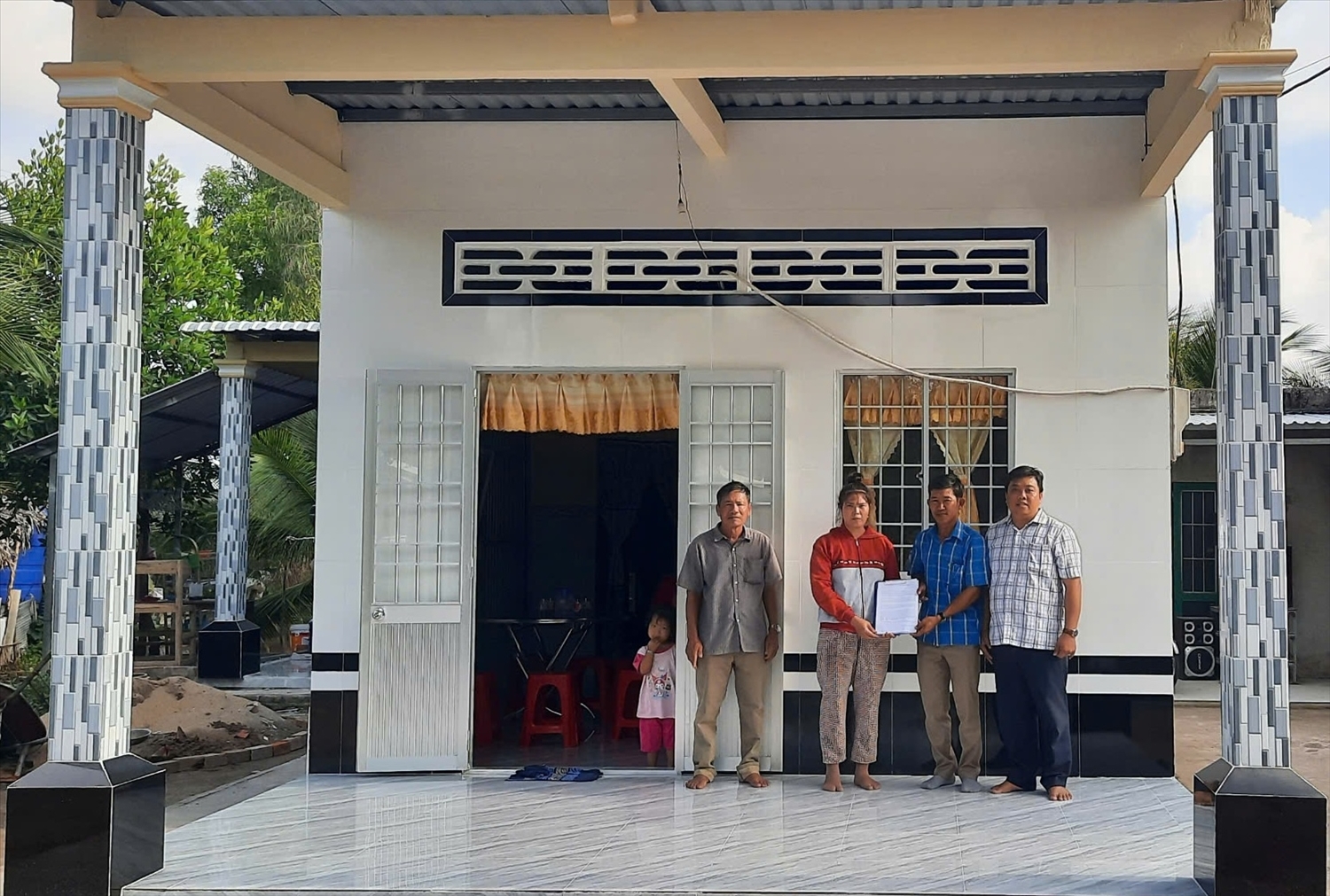 Bà Hữu Thị Lan ở ấp 11, xã Thới Bình, tỉnh Cà Mau, được nhận nhà trước Tết cổ truyền Chôl Chnăm Thmây năm 2025 (Trong ảnh: Đại diện gia đình bà Lan nhận Quyết định trao nhà từ chính quyền địa phương)