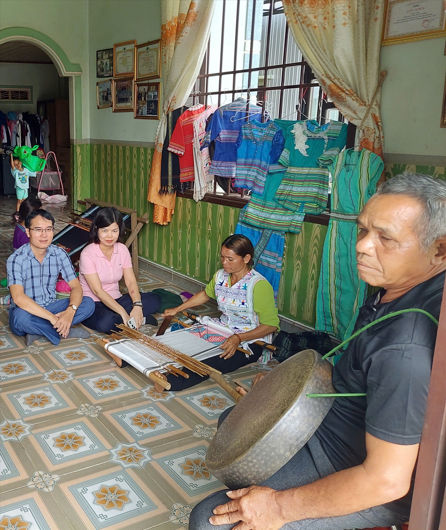 Tác giả (ngoài cùng bên trái) và PGs.Ts. Vũ Thị Phương Hậu (thứ hai từ trái qua) - Viện trưởng Viện Văn hóa và Phát triển, Học viện Chính trị Quốc gia Hồ Chí Minh, tham quan mô hình dệt thổ cẩm tại Đạ Nghịch.