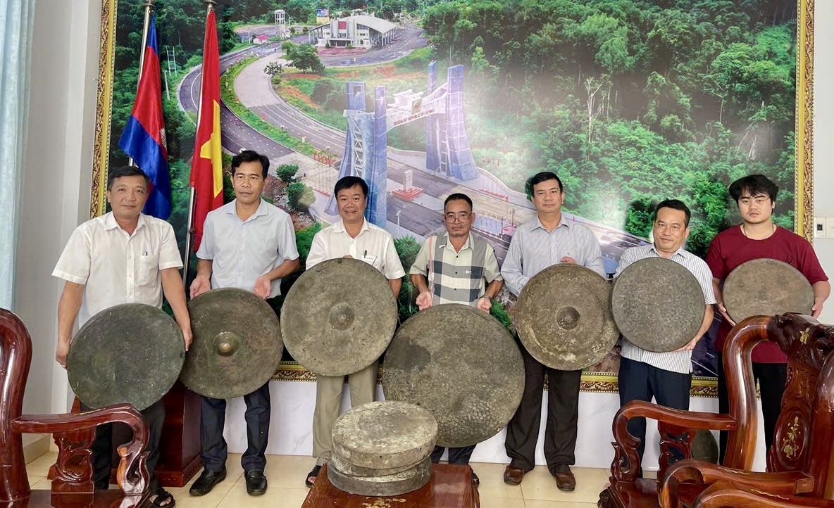 Anh Vũ Văn Hiếu (ở giữa) hiến tặng bộ chiêng quý gồm 19 món cho chính quyền xã Ia Dom