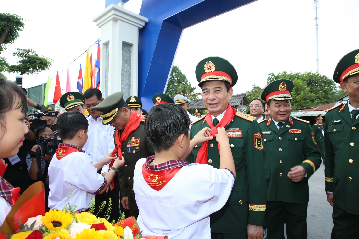 Các cháu học sinh Trường Tiểu học Bến Cầu choàng khăn quàng cho Bộ trưởng Bộ Quốc phòng hai nước 