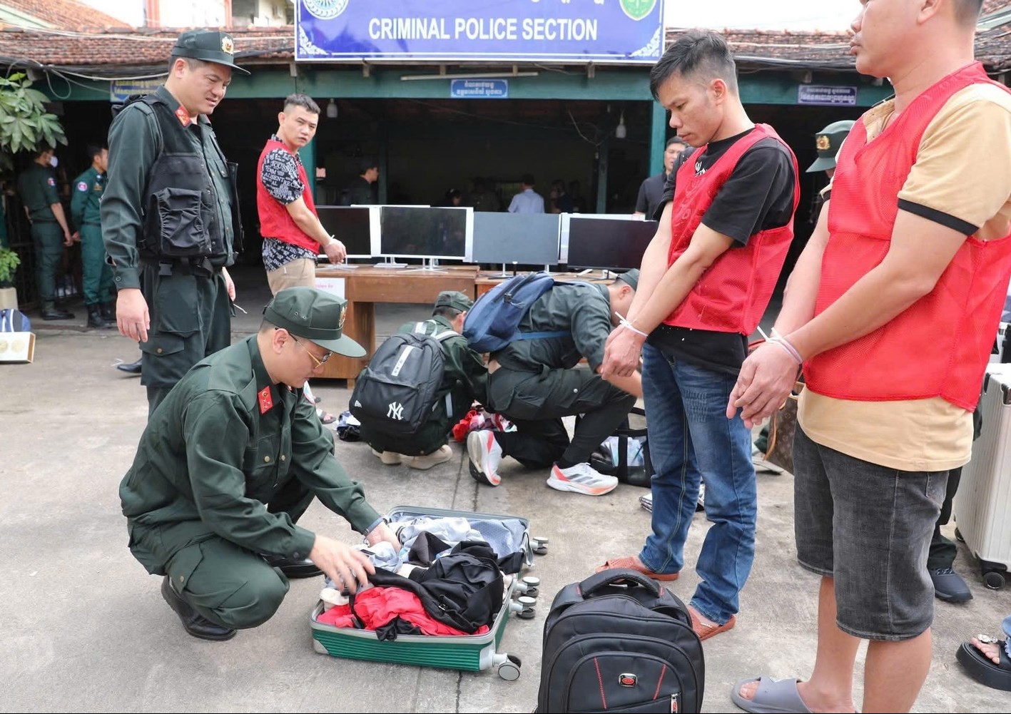 Lực lượng chức năng kiểm tra hành lý các đối tượng trong đường dây lừa đảo công nghệ cao.