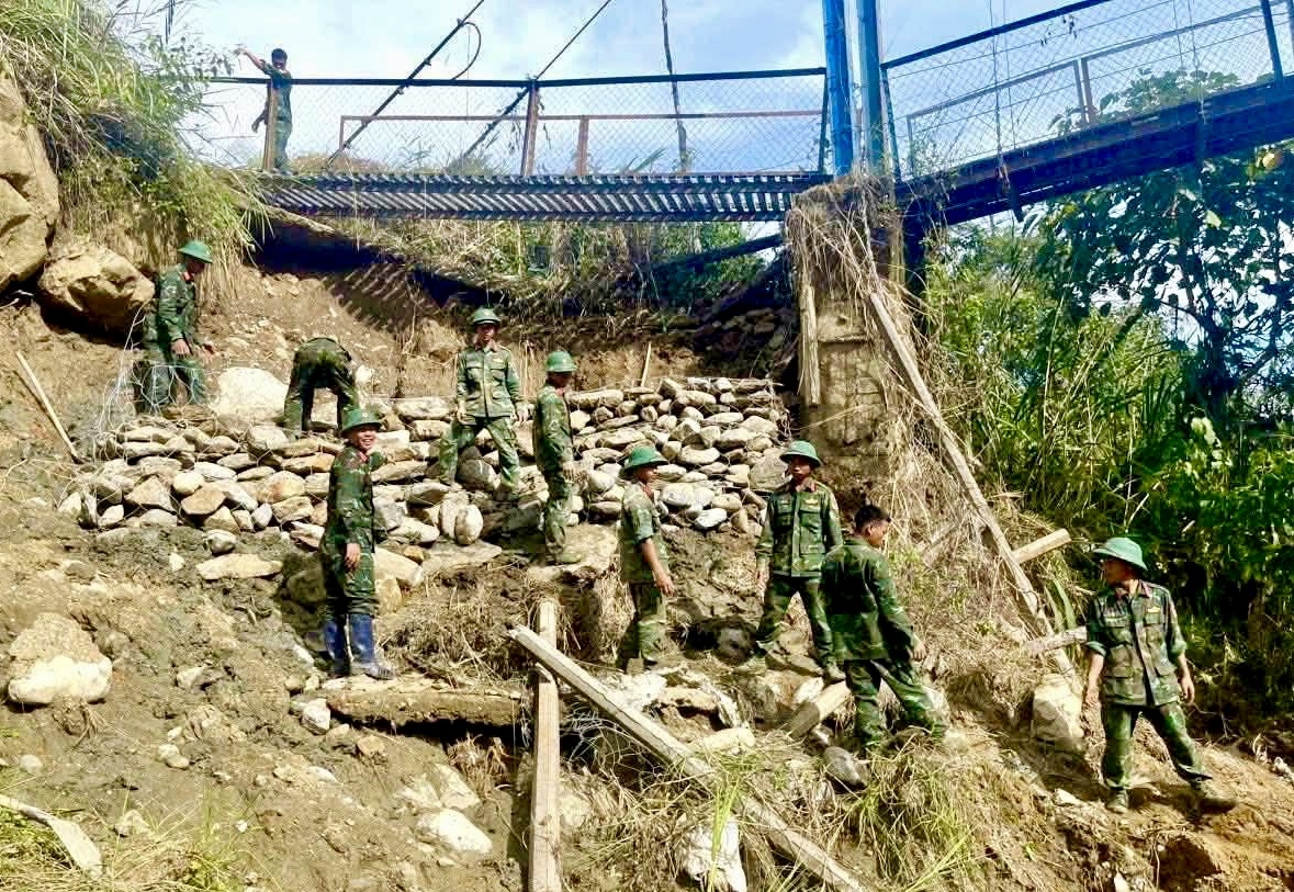 Lực lượng bộ đội khắc phục sạt lở mố cầu treo lên thôn Đăk Nai, xã Ngọc Linh. (Ảnh: Ngọc Chí)