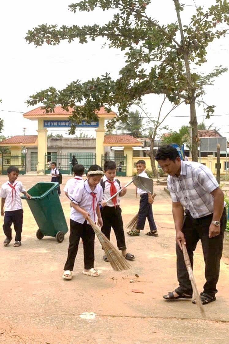 Mỗi buổi sáng đến trường, thầy giáo Y Giêng cùng học sinh dọn vệ sinh trường học. (Ảnh: H.H.Thế)