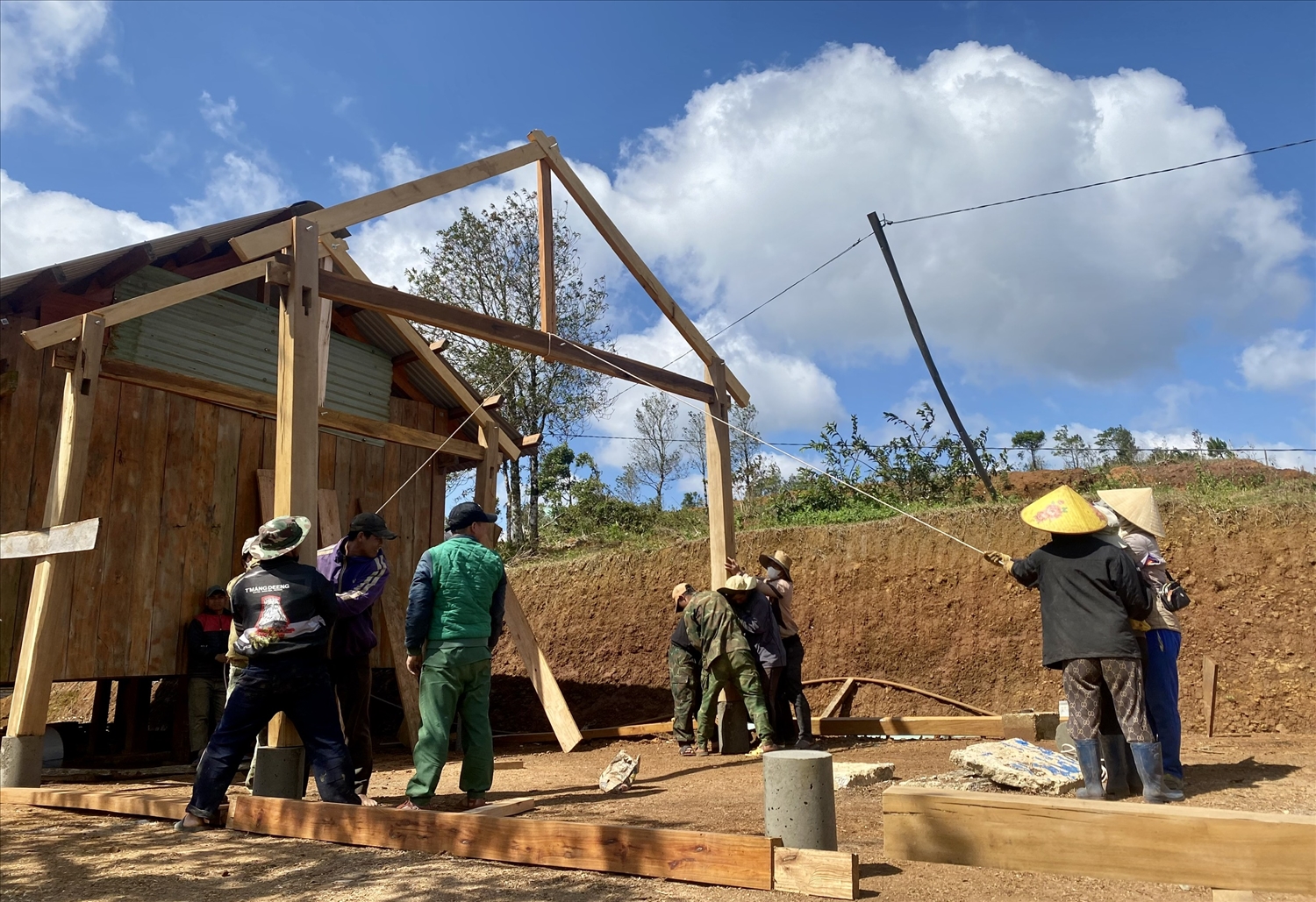 Anh A Nấc giúp bà con trong làng dựng nhà sàn truyền thống để làm homestay phục vụ du khách. (Ảnh: Ngọc Chí)