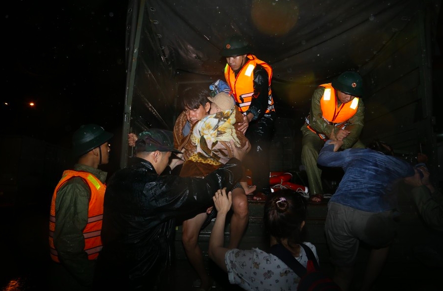 Lực lượng chức năng hỗ trợ di dời người dân đến nơi an toàn. (Ảnh: A.T)