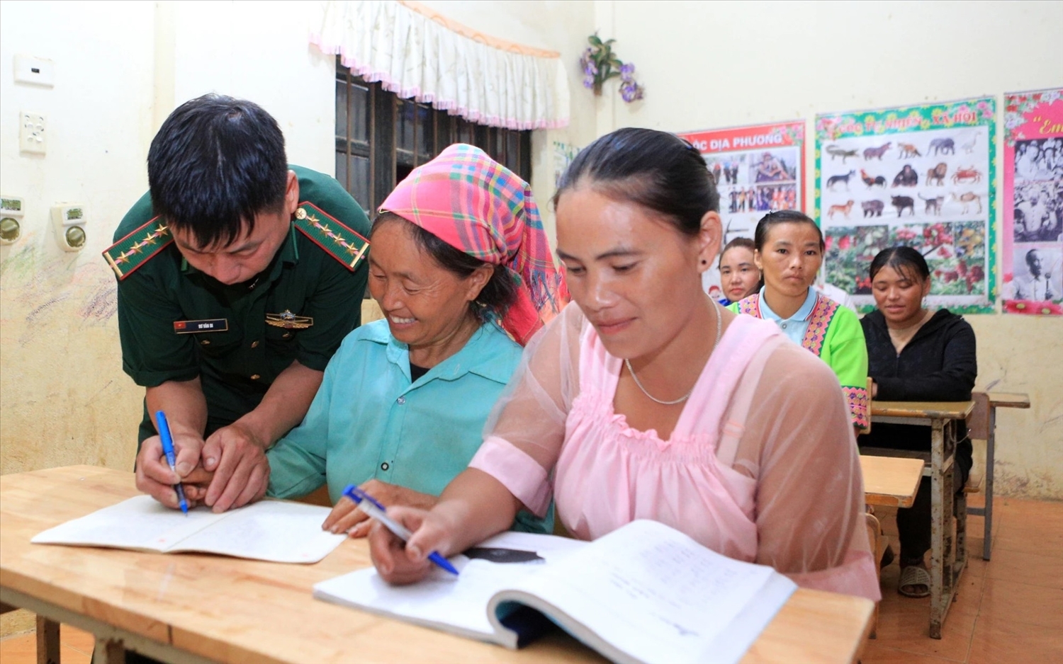 Cán bộ Đồn Biên phòng Trung Lý hướng dẫn học viên người Mông trong lớp xóa mù chữ tại xã Trung Lý.
