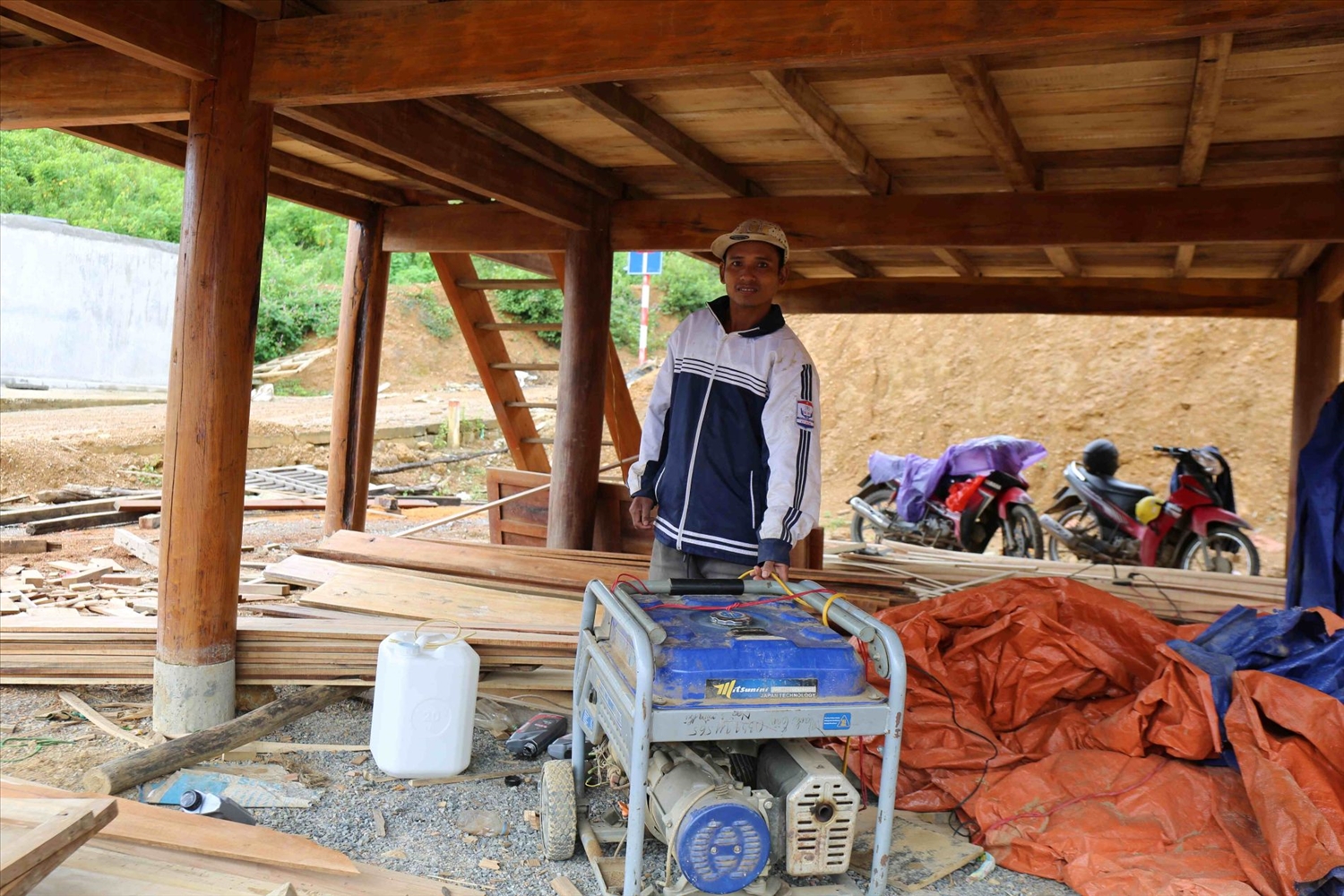 Người dân khu Tái định cư vùng lũ ở xã Mường Xén chạy máy nổ để dựng nhà - Ảnh: Thanh Hải