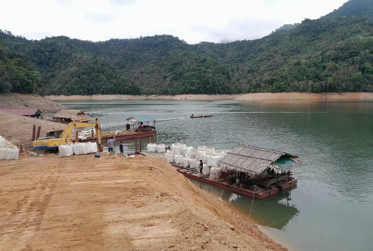 Vận chuyển nguyên vật liệu bằng phà, thuyền vượt lòng hồ Thủy điện bản Vẽ cũng là nguyên nhân khiến cho tiến độ thi công dự án mở đường nơi đây chậm tiến độ