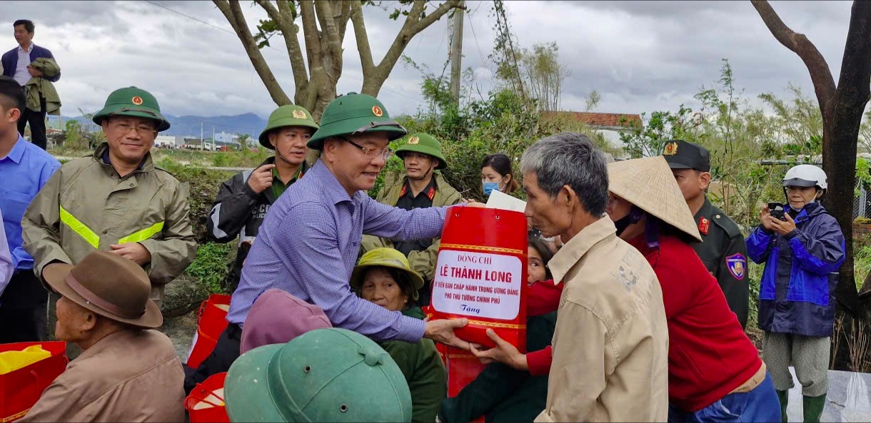 Phó Thủ tướng Chính phủ Lê Thành Long tặng quà cho bà con vùng lũ Tuy Phước, tỉnh Gia Lai. (Ảnh: T.N)