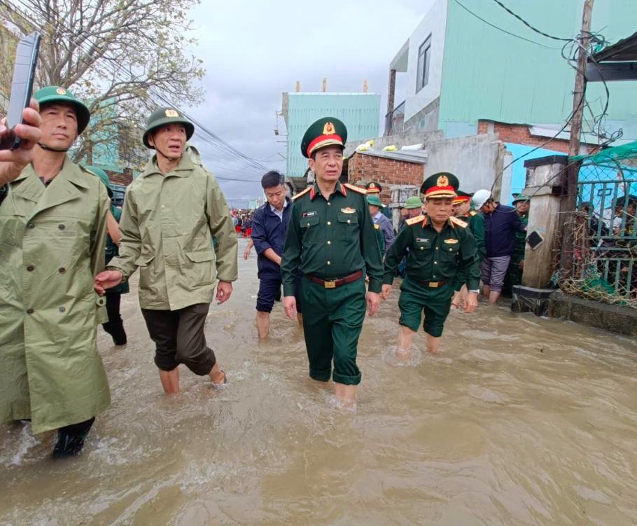 Đại tướng Phan Văn Giang lội nước vào thăm bà con vùng lũ xã Tuy Phước Đông, tỉnh Gia Lai. (Ảnh: T.N)