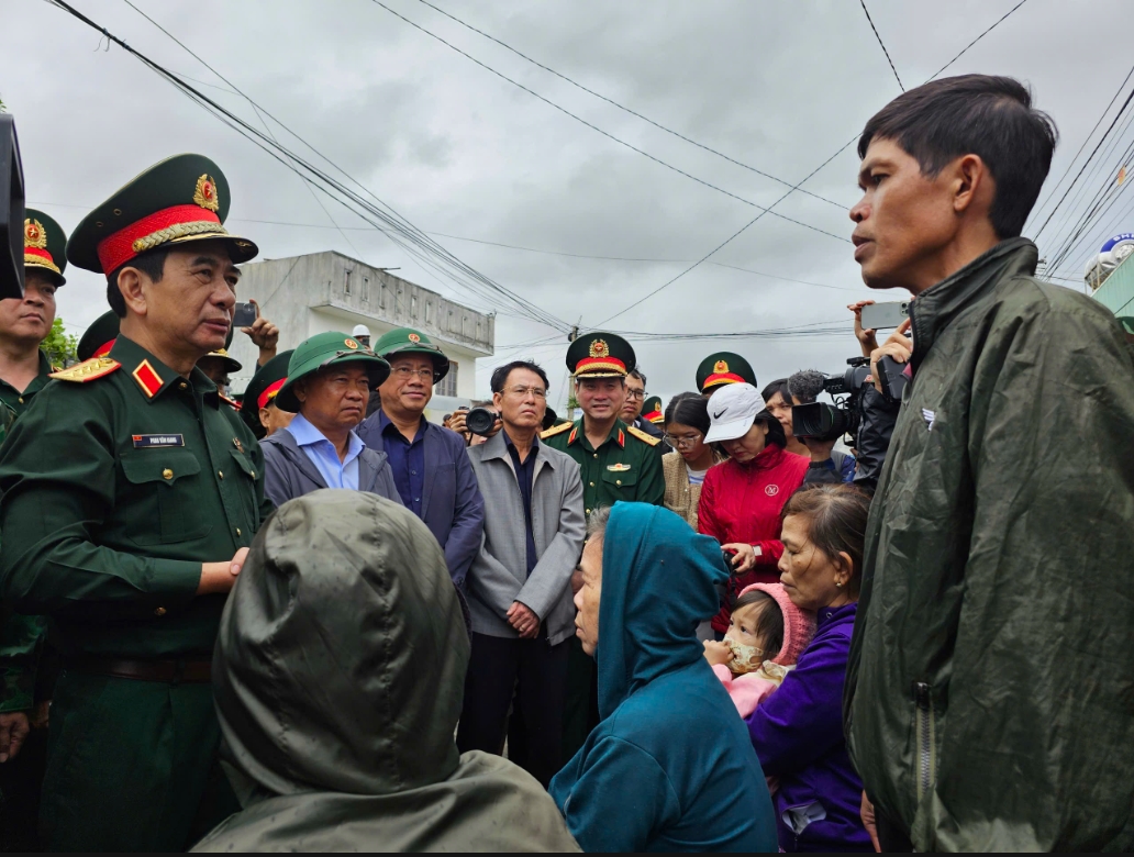 Người dân vùng lũ xã Tuy Phước Đông, tỉnh Gia Lai thông tin với Đại tướng Phan Văn Giang về tình hình thiệt hại do bão lũ gây ra tại địa phương. (Ảnh: T.N)