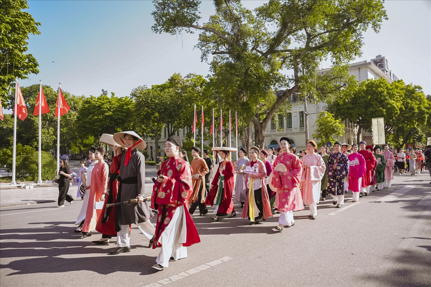 Đoàn diễu hành áo dài thướt tha tiến bước qua các tuyến phố lịch sử ở Hà Nội, tạo nên hình ảnh văn hóa giàu cảm xúc và tinh tế.