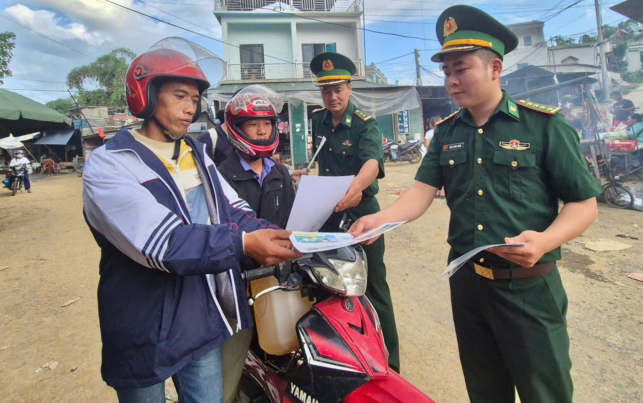 Cán bộ Biên phòng phát tờ rơi tuyên truyền pháp luật cho Nhân dân vùng biên giới.