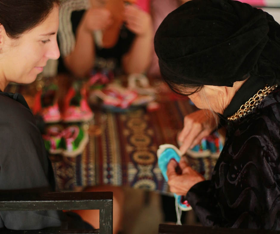 Nghệ nhân hướng dẫn du khách công đoạn làm đôi giày truyền thống trong workshop của dự án