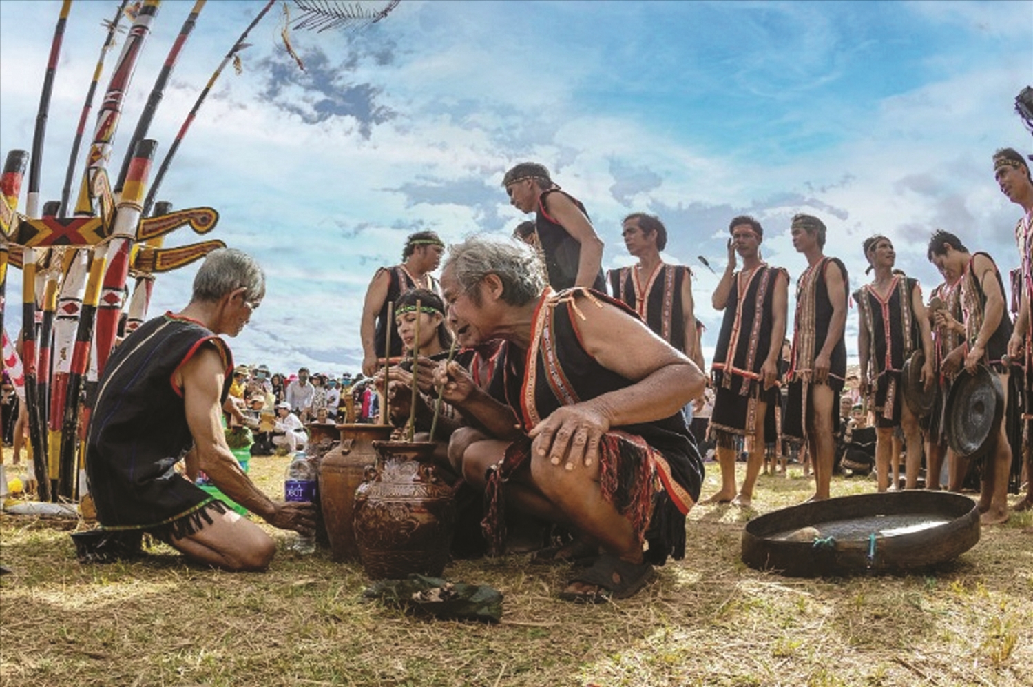 Dưới sân nhà rông, mỗi hộ gia đình gùi một ghè rượu được ủ từ gạo mới, cơm lúa mới được bày ra xếp xung quanh cây nêu để cùng góp mừng lễ mới