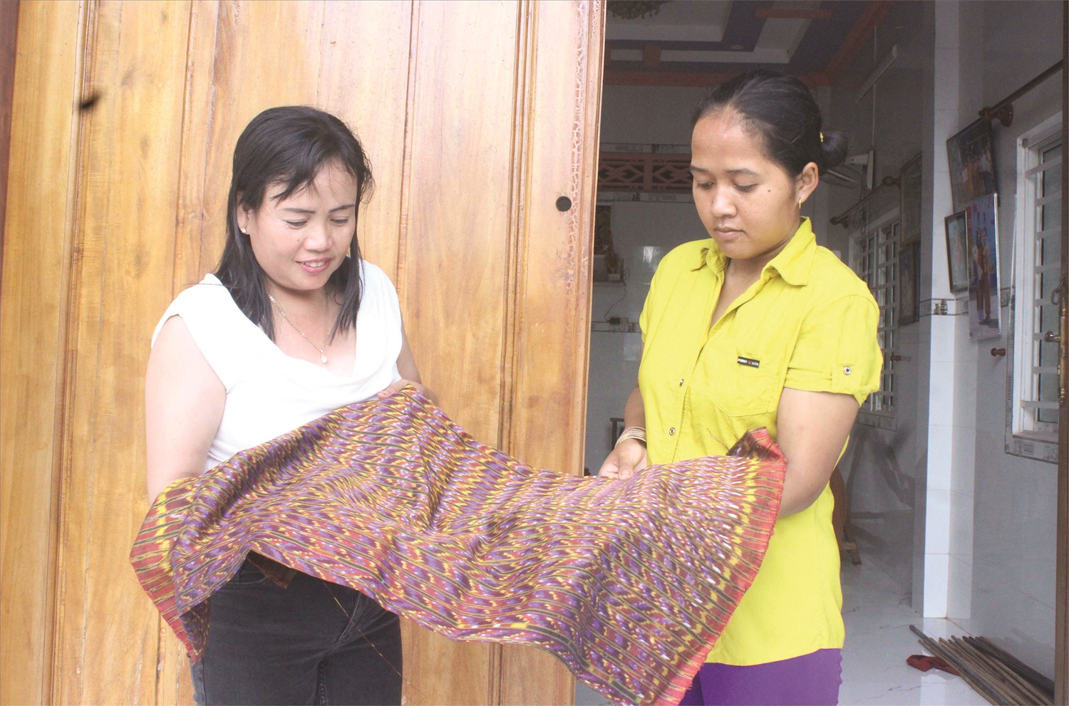 Chị Neáng Chanh Ty (bên trái) tự hào chia sẻ về các sản phẩm thổ cẩm của làng nghề