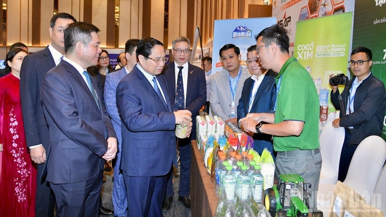 Thủ tướng Phạm Minh Chính tham quan một gian trưng bày sản phẩm tiêu biểu nhân Diễn đàn Logistics Việt Nam. (Ảnh: Thanh Giang) 