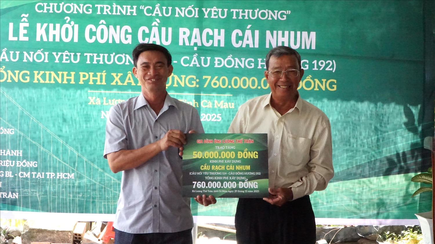 Ông Trương Thành Tài ( bìa phải) đại diện gia đình liệt sĩ Lương Thế Trân trao bảng tượng trưng hỗ trợ kinh phí xây cầu đến đại diện lãnh đạo xã Lương Thế Trân 