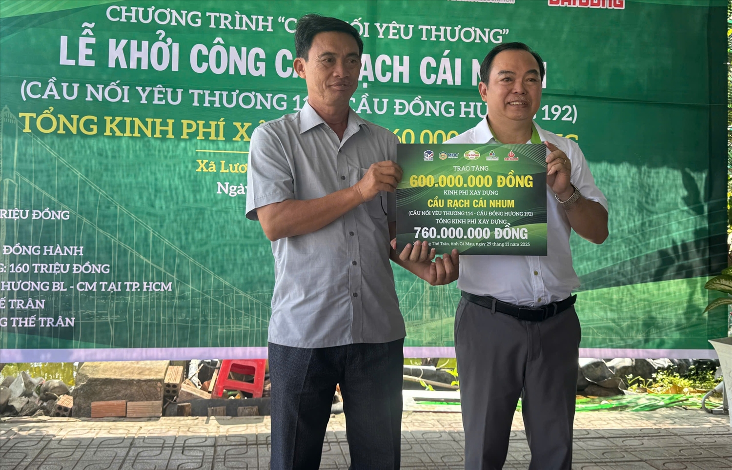 Ông Nguyễn Ngọc Tâm ( bìa phải), đại diệnTiền Phong Nam trao bảng tượng trưng hỗ trợ kinh phí xây cầu đến đại diện lãnh đạo xã Lương Thế Trân 