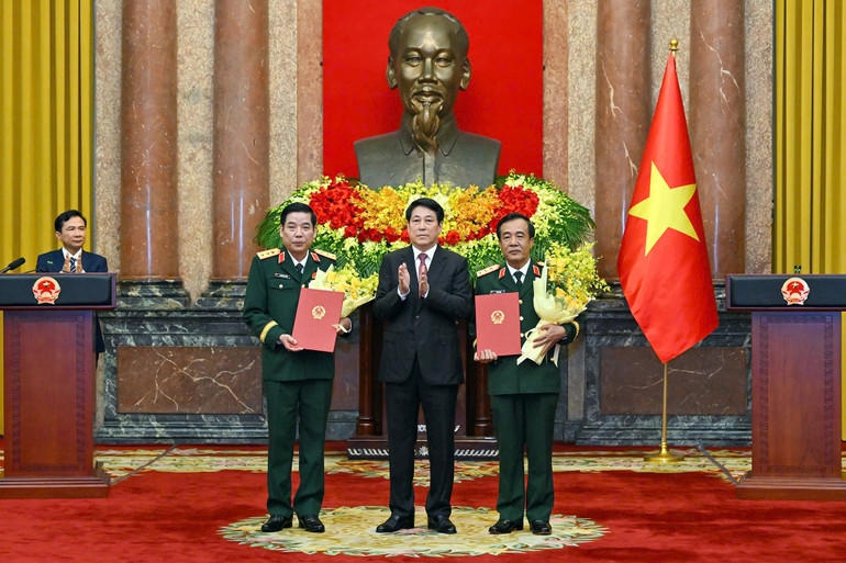 Chủ tịch nước Lương Cường trao quyết định và tặng hoa chúc mừng các đồng chí Nguyễn Văn Gấu và Lê Đức Thái. (Ảnh: Thủy Nguyên)