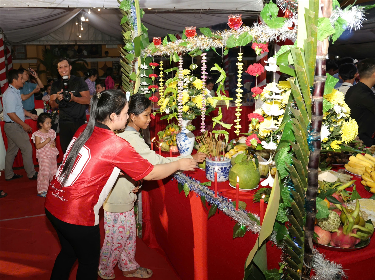 Ngoài ra, bà con còn trang trí 2 cây trụ làm cổng ngay bàn cúng tượng trưng cho “Vành đai vũ trụ”. 3 cây nến cắm trên cổng tượng trưng cho 3 mùa trong năm là “nắng, mát, mưa“.