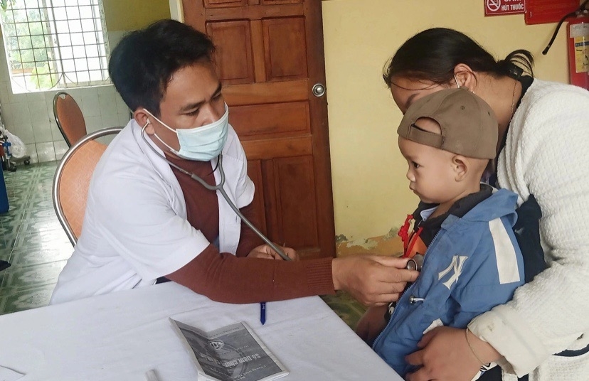 Bác sĩ La Văn Vinh thăm khám sức khỏe cho trẻ em người Đan Lai tại xã Môn Sơn