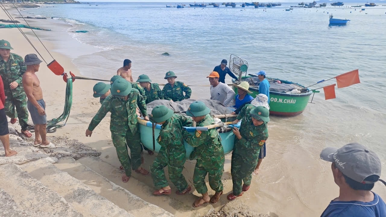 Cán bộ, chiến sĩ Đồn Biên phòng Nhơn Châu giúp người dân đưa thuyền, thúng neo đậu vào nơi an toàn