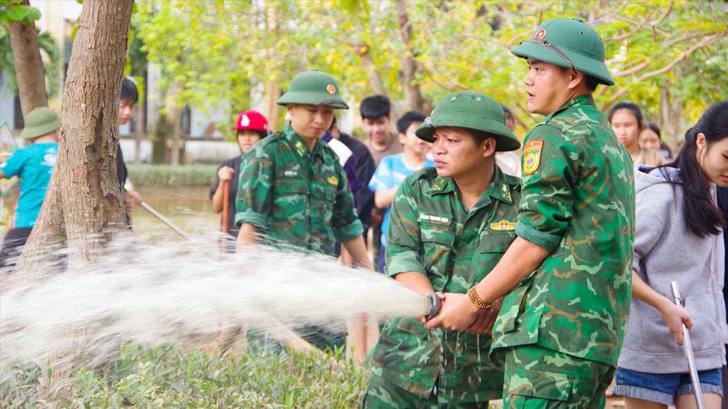 Chiến sĩ BĐBP Quảng Trị sử dụng vòi nước áp suất cao để rửa bùn đất. (Ảnh: Khánh Ngân)