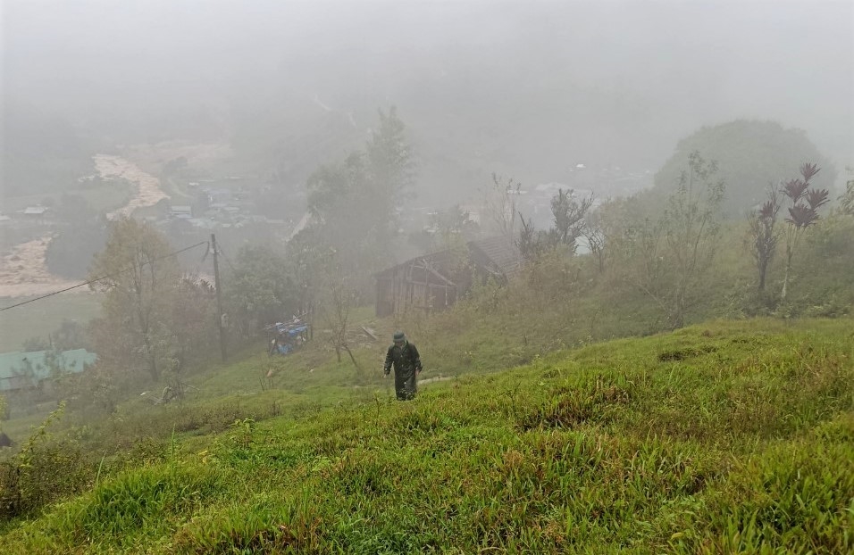 Cán bộ xã Ngọc Linh đi kiểm tra thực tế các vết nứt ở quả đồi phía trên làng Đăk Rế. (Ảnh: Ngọc Chí)
