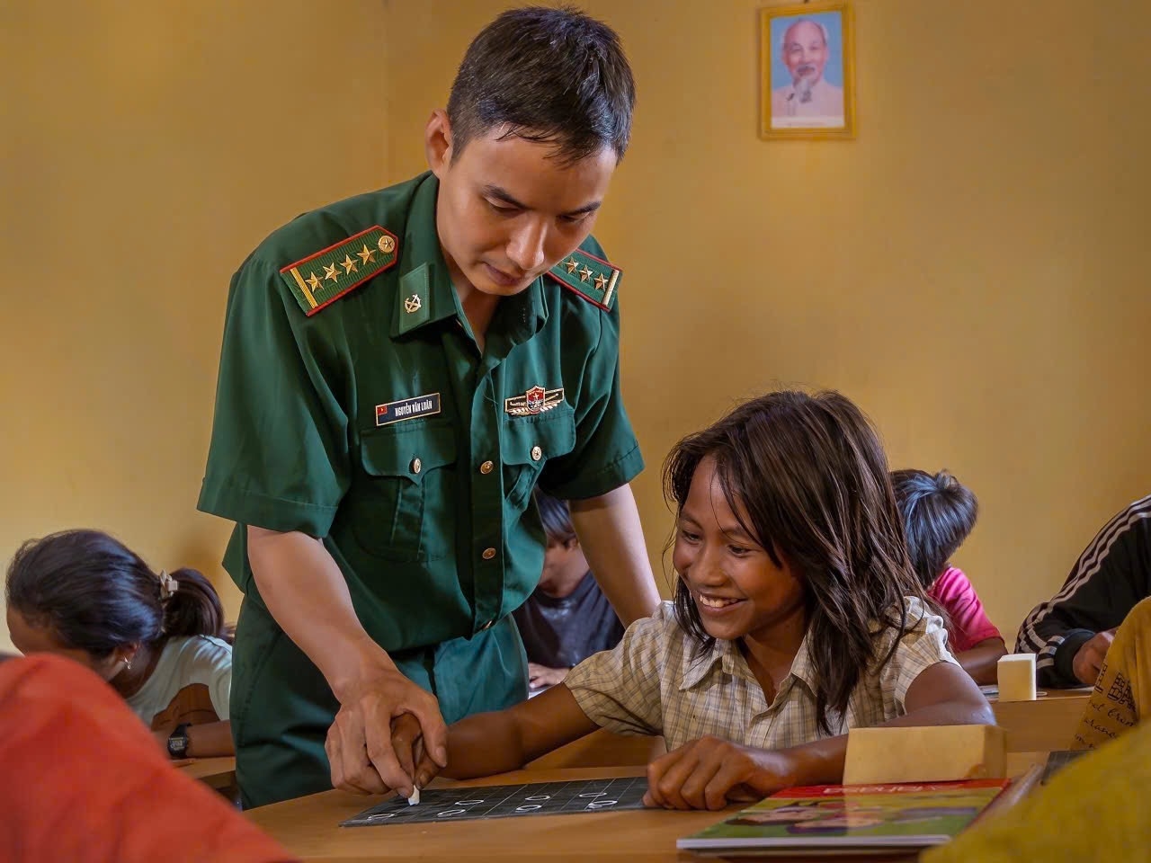 Thiếu tá Nguyễn Văn Luân, Đội trưởng Đội Vận động quần chúng, Đồn Biên phòng Ia Lốp dạy người dân làng Khôn biết đọc, biết viết