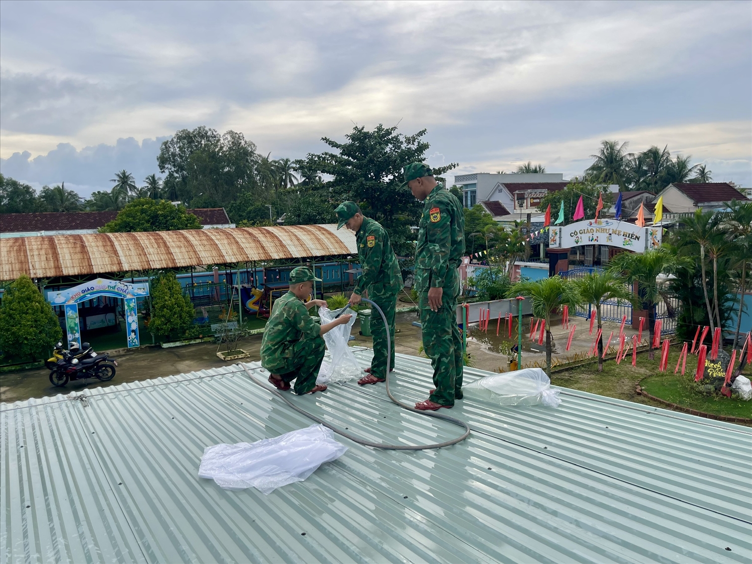 Lực lượng chức năng giúp dân chằn chống nhà cửa. (Ảnh Thi Thi)