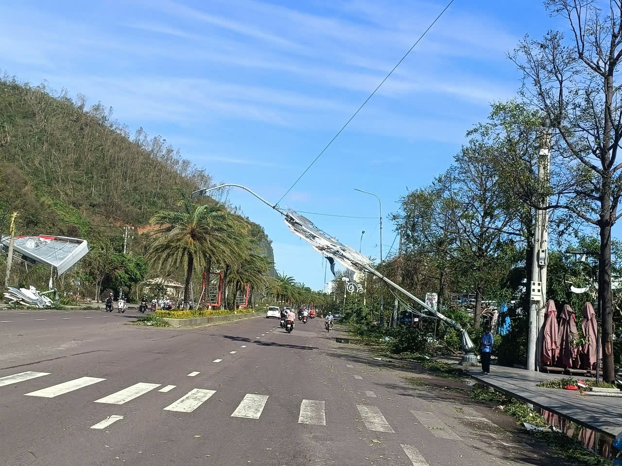 Đèn đường bị ngã sau bão. (Ảnh Lê Phương)