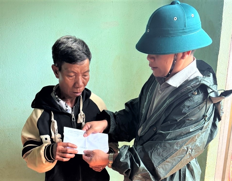 Ông A Tuân, Bí thư Đảng ủy xã Ngọk Réo thăm hỏi và hỗ trợ gia đình có người bị tử vong do cơn bão số 13. (Ảnh: Ngọc Chí) 