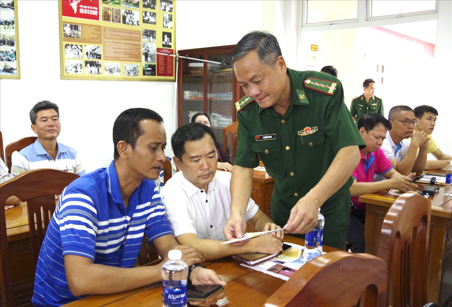 Cán bộ Trạm Biên phòng cửa khẩu cảng Hiệp Phước (thuộc Ban Chỉ huy Biên phòng cửa khẩu cảng TP. Hồ Chí Minh) tờ rơi cho các chủ phương tiện (Ảnh: Mai Lan)