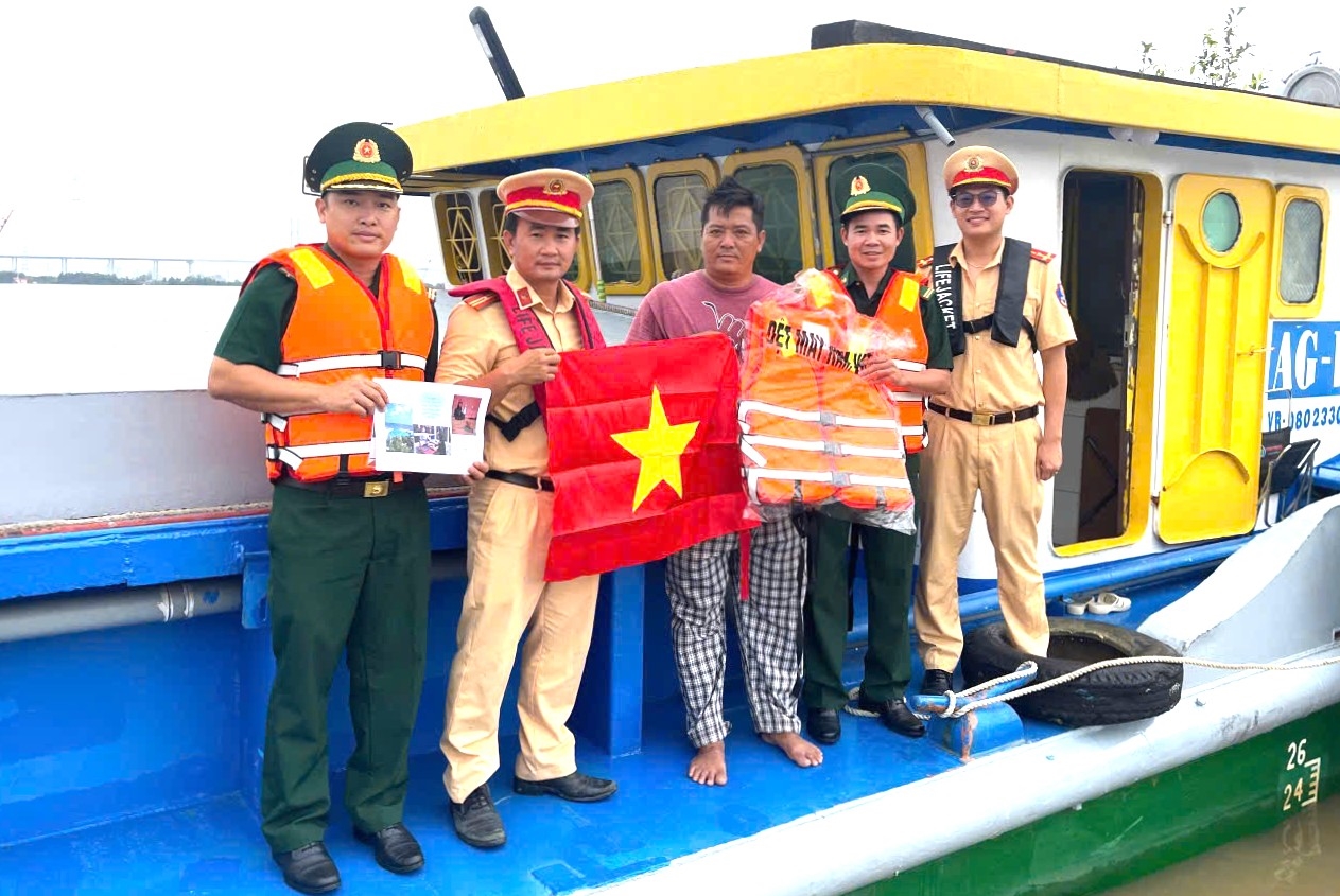 Các đơn vị phối hợp tặng áo phao và cờ Tổ quốc cho các chủ phương tiện (Ảnh: Mai Lan)