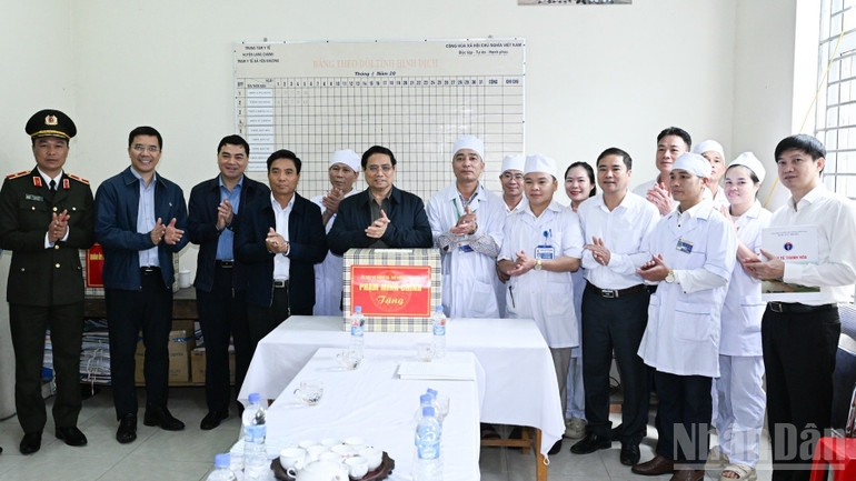 Thủ tướng Phạm Minh Chính tặng quà động viên cán bộ, nhân viên Trạm Y tế xã Yên Khương. (Ảnh: TRẦN HẢI)