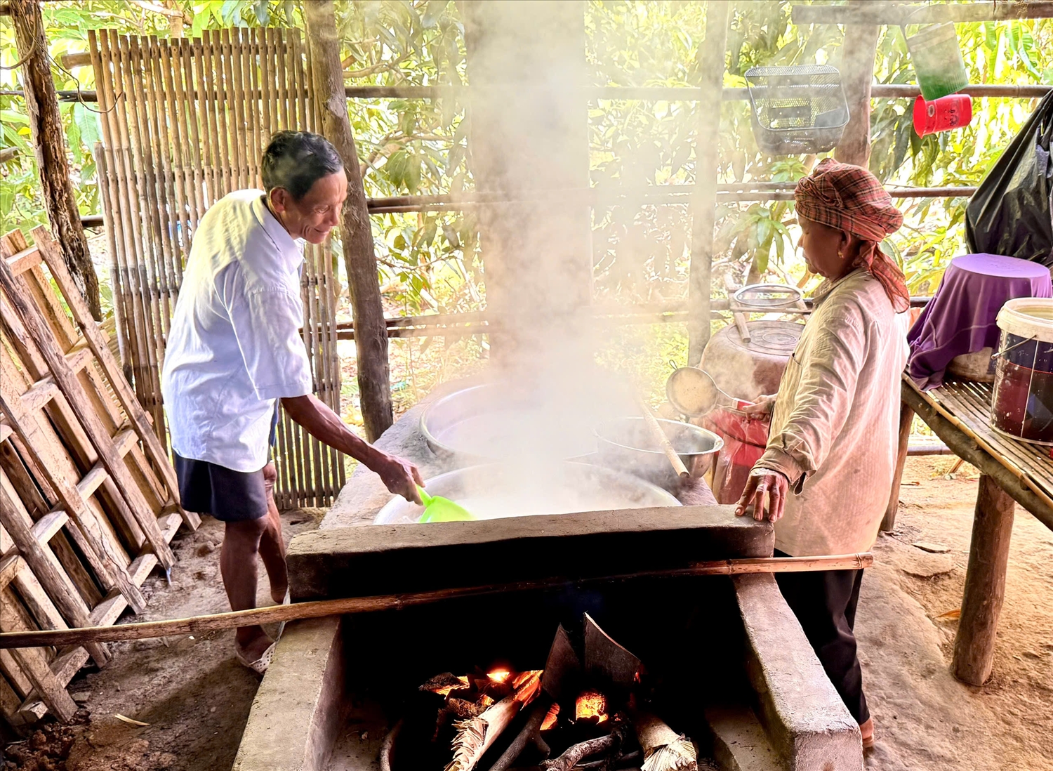 Vợ chồng ông Chau Bê và bà Neang Tum ( xã Ô Lâm) trong công việc nấu đường thốt nốt theo phương pháp truyền thống 