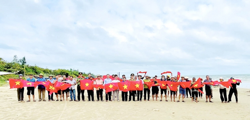 Công an xã Kỳ Anh, tỉnh Hà Tĩnh tuyên truyền để bà con tuân thủ các quy định về VMS và tặng cờ Tổ quốc cho ngư dân trên địa bàn (Ảnh MH)