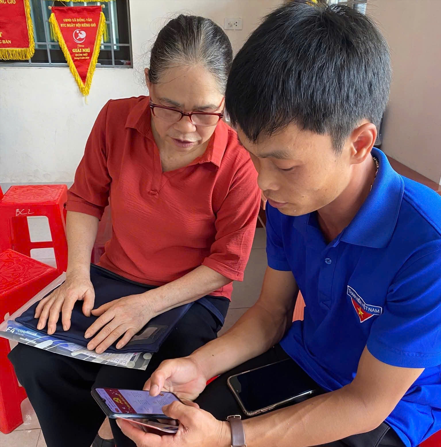 Thanh niên hỗ trợ người dân trong thôn bản thực hiện chuyển đổi số