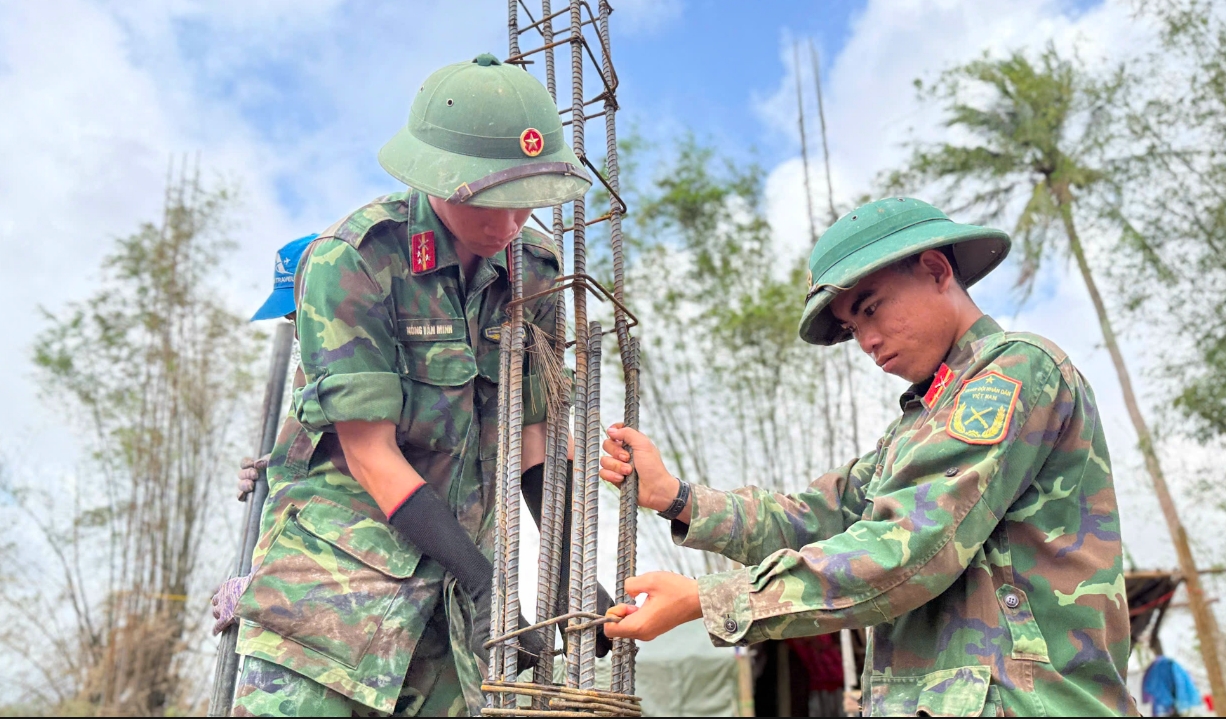 Những chú bộ đội trong vai thợ xây giúp dân dựng lại nhà. (Ảnh: T.Q)
