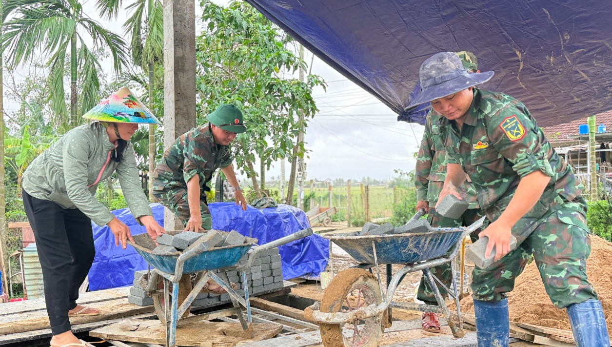 Các chiến sĩ bộ đội đang chạy đua với thời gian để hoàn thành việc xây nhà cho người dân kịp tiến độ đề ra. (Ảnh: T.Q)