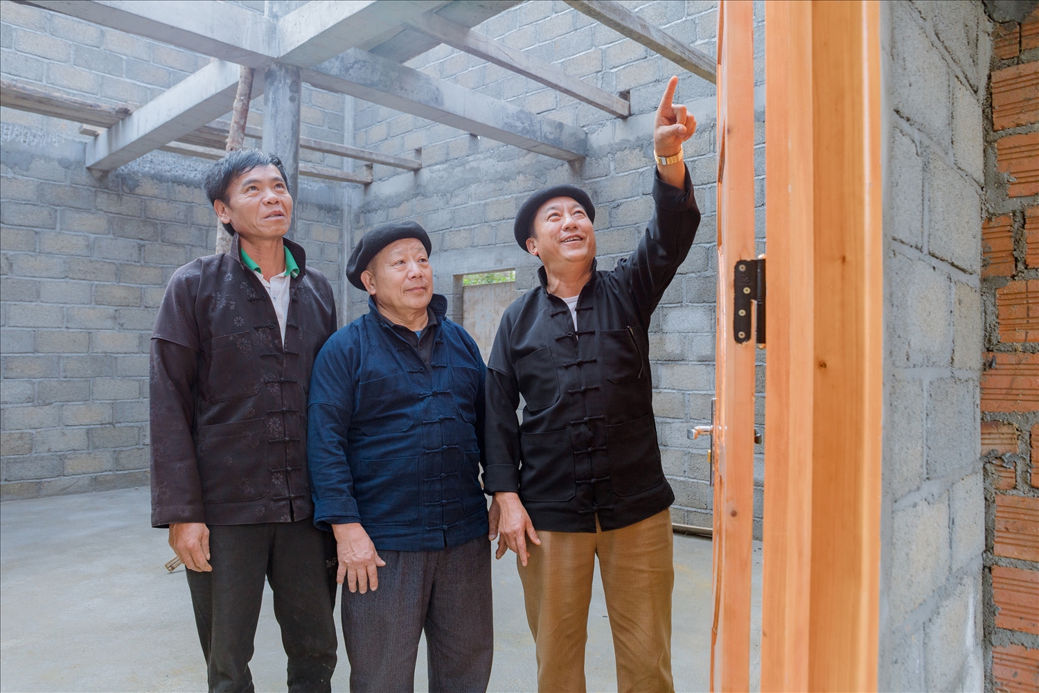 Ông Mua Nảo Cha thăm căn nhà mới đang trong quá trình hoàn thiện của anh Hầu Mí Phìn (bên trái bức ảnh)