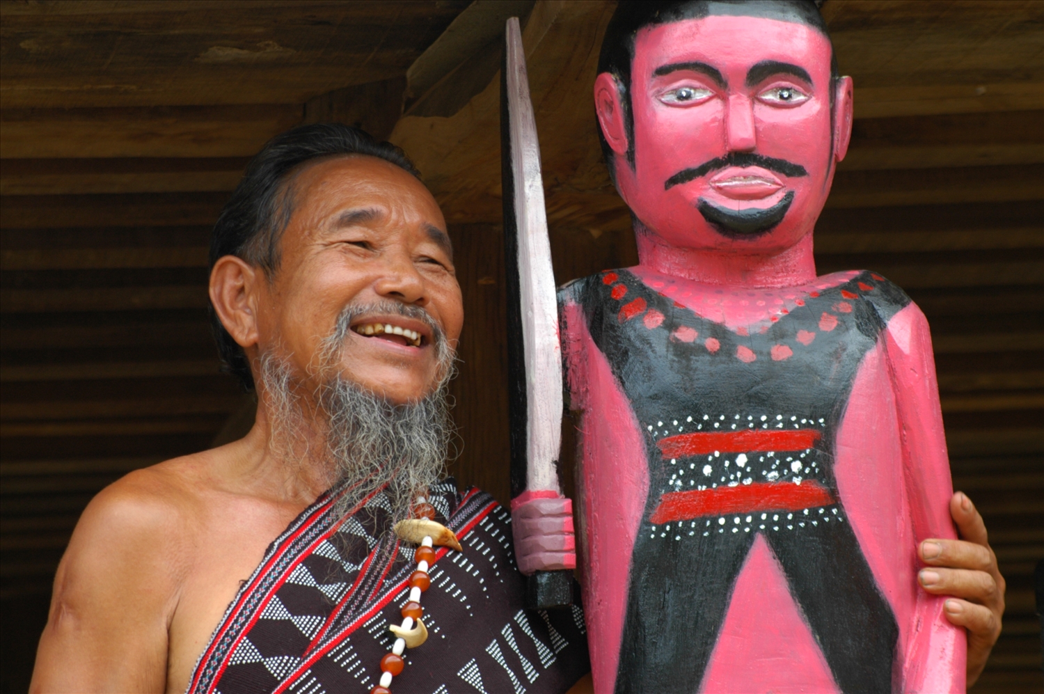 Nghệ nhân Y Kông bên tác phẩm điêu khắc vừa hoàn thành.