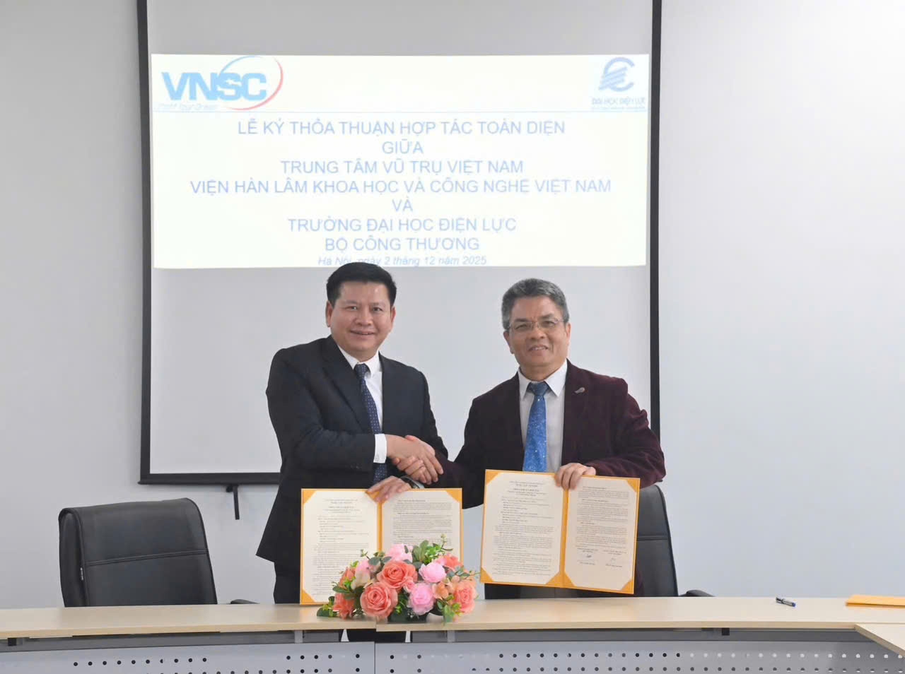 PGS,TS. Đinh Văn Châu (bên trái), PhóBí thư Đảng ủy, Hiệu trưởng, Trường Đại học Điện lực trao Biên bản hợp tác cho PGS,TS.Phạm Anh Tuấn, Tổng Giám đốc Trung tâm Vũ trụ Việt Nam